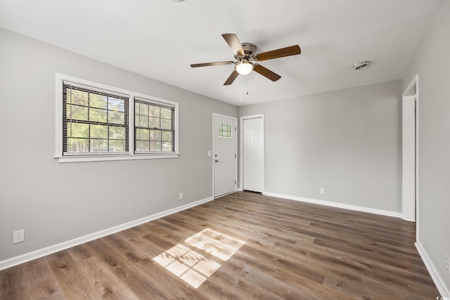 unfurnished room with baseboards, wood finished floors, and ceiling fan