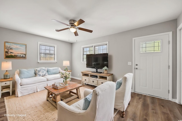 living room featuring baseboards, a ceiling fan, and wood finished floors