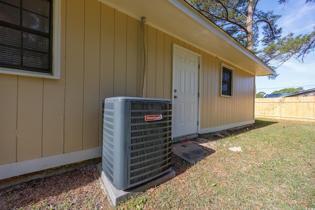 exterior space featuring a yard, fence, and cooling unit