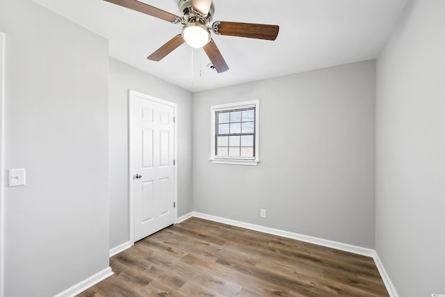 unfurnished room with baseboards, a ceiling fan, and wood finished floors