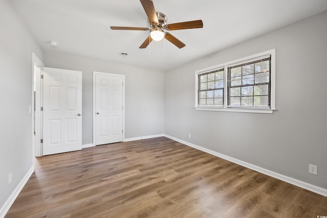 unfurnished bedroom featuring wood finished floors, ceiling fan, and baseboards