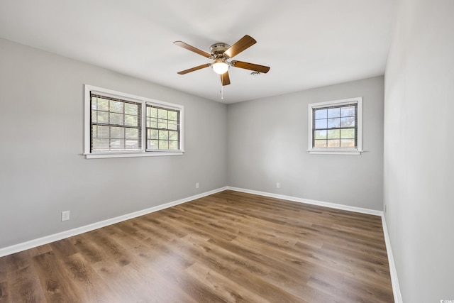 unfurnished room featuring baseboards, a ceiling fan, and wood finished floors