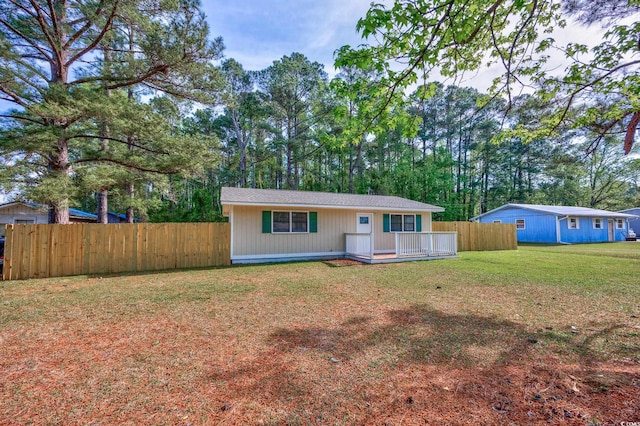 rear view of property with fence and a lawn