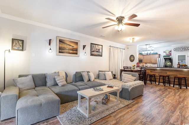living area featuring ornamental molding, a ceiling fan, and wood finished floors