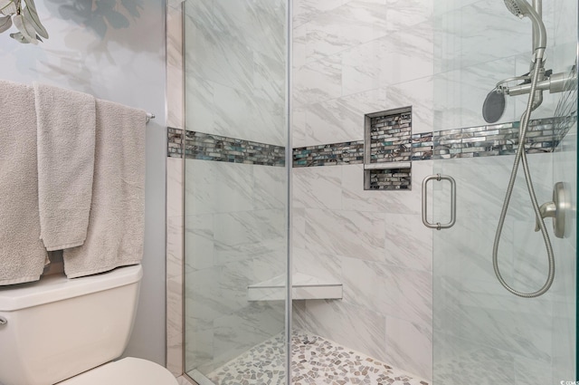 bathroom featuring a shower stall and toilet