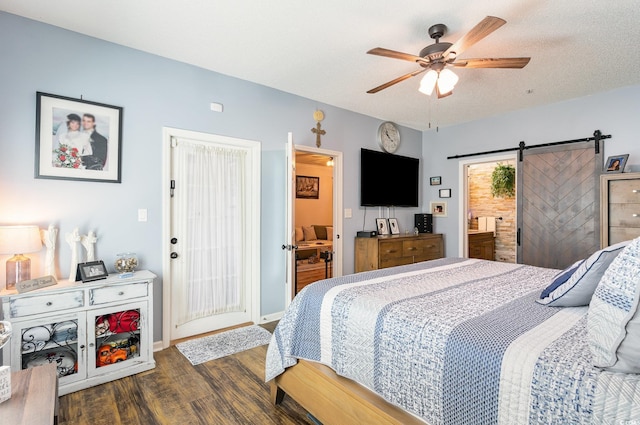 bedroom with baseboards, a barn door, a ceiling fan, connected bathroom, and wood finished floors