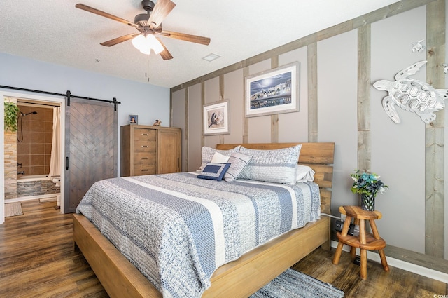 bedroom with ceiling fan, a barn door, and wood finished floors