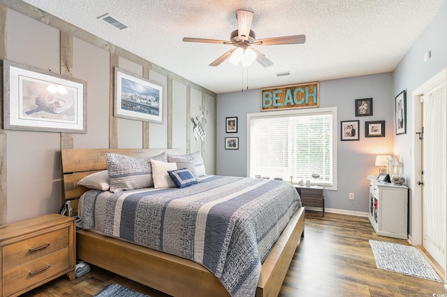 bedroom with a textured ceiling, wood finished floors, and visible vents