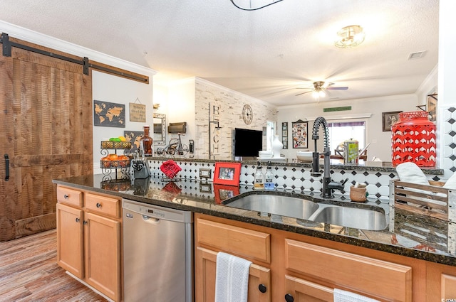 kitchen featuring crown molding, stainless steel dishwasher, light wood-type flooring, visible vents, and a sink