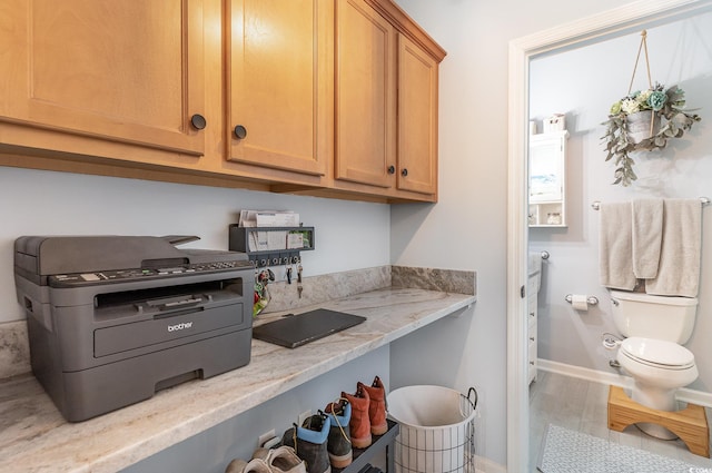 interior space featuring baseboards, light stone counters, and wood finished floors