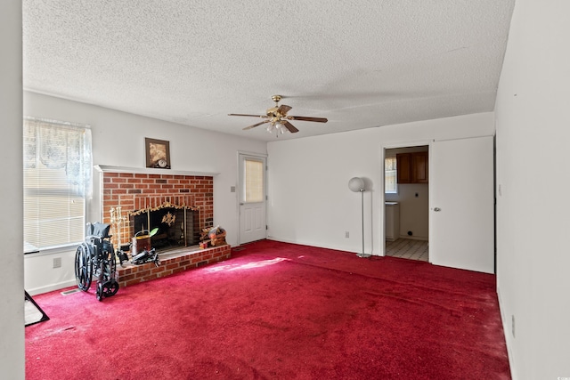 carpeted living area with a fireplace, a textured ceiling, baseboards, and ceiling fan
