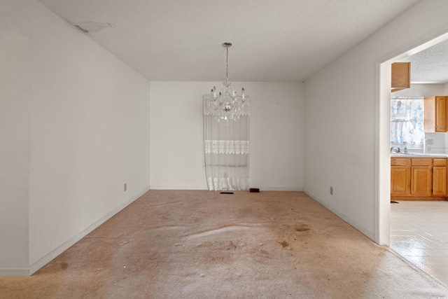 unfurnished dining area featuring light carpet, a chandelier, and baseboards