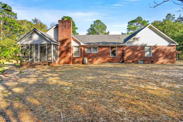 rear view of house with a chimney, crawl space, a sunroom, and brick siding