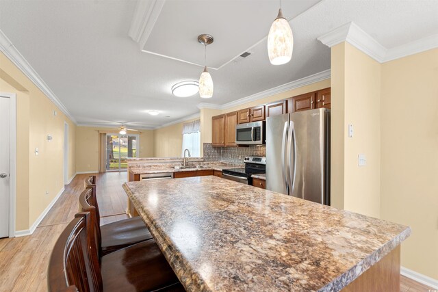 820 Fairway Dr Unit 1506Hh, Longs, SC 29568 - kitchen with appliances with stainless steel finishes, a sink, a peninsula, light wood-style floors, and crown molding