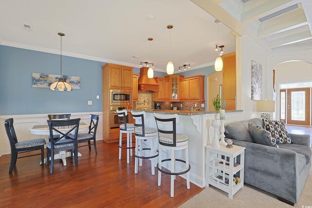 4017 Chalmers Ct, Myrtle Beach, SC 29579 - kitchen with a kitchen bar, arched walkways, ornamental molding, stainless steel appliances, and brown cabinets