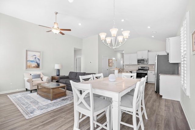 dining space featuring a chandelier, high vaulted ceiling, wood finished floors, ceiling fan, and baseboards