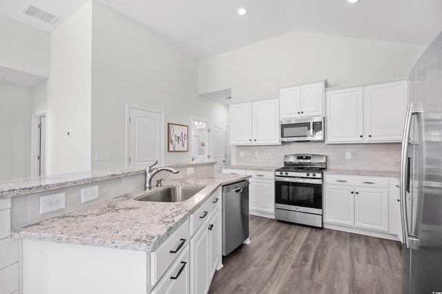 kitchen with stainless steel appliances, a sink, white cabinets, high vaulted ceiling, and dark wood-style flooring