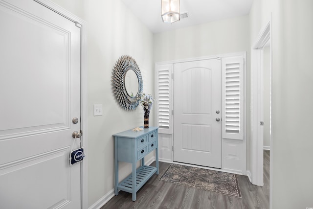 foyer entrance with dark wood-type flooring and baseboards
