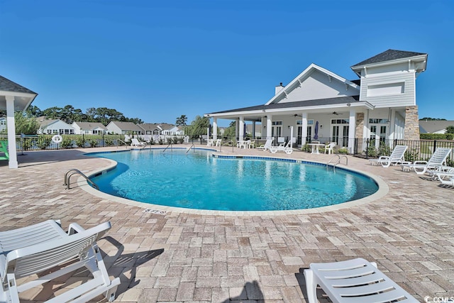 community pool featuring fence, ceiling fan, and a patio area