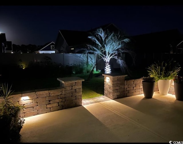 patio at twilight with a fenced backyard