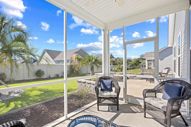 sunroom / solarium with ceiling fan and a residential view