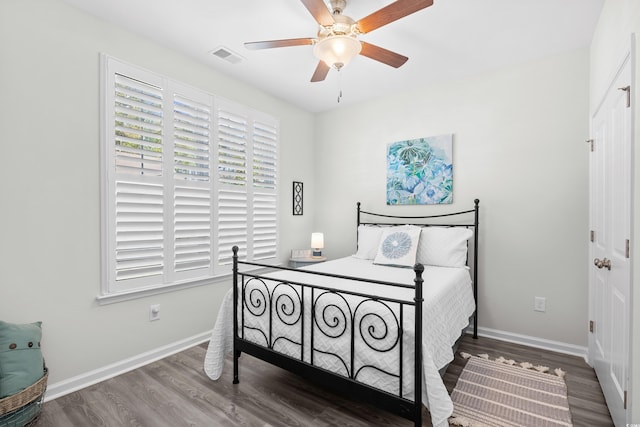 bedroom with wood finished floors, baseboards, a ceiling fan, and a closet
