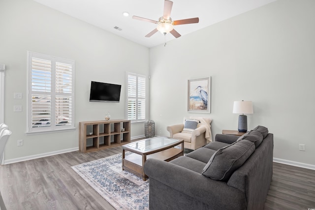 living room featuring wood finished floors, a ceiling fan, and baseboards