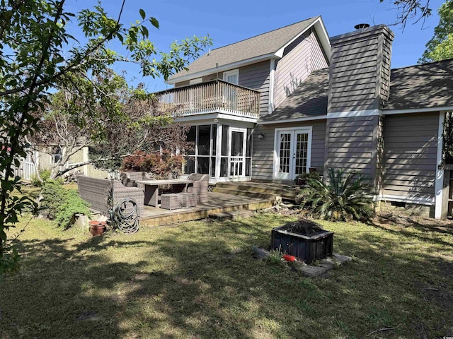 rear view of house featuring a yard, french doors, a shingled roof, and a chimney