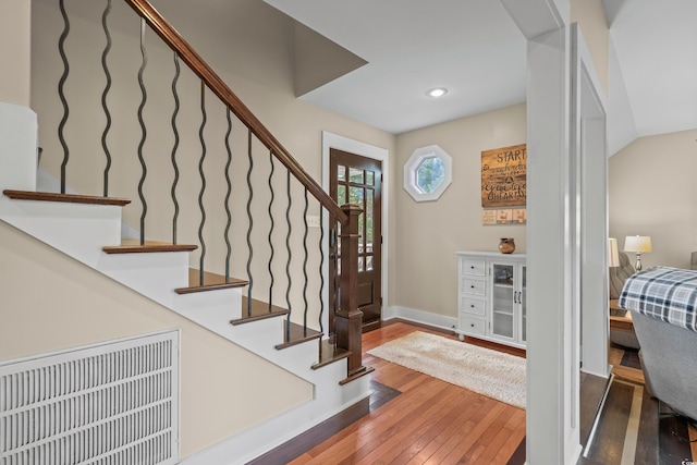 foyer entrance with stairway, baseboards, and hardwood / wood-style floors