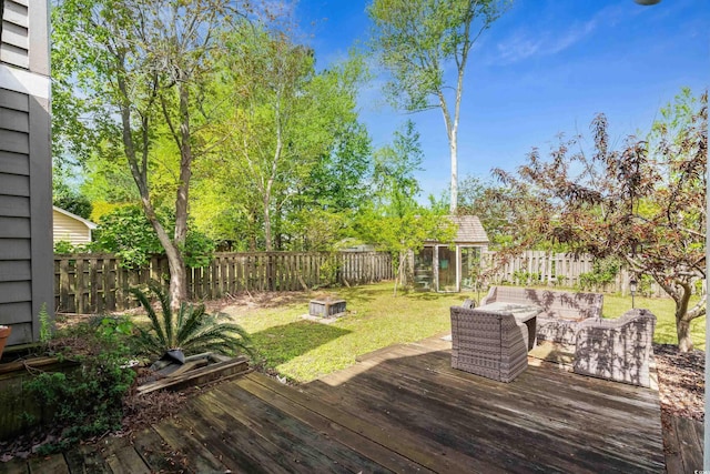 deck featuring a yard, a fenced backyard, outdoor lounge area, and an outdoor structure