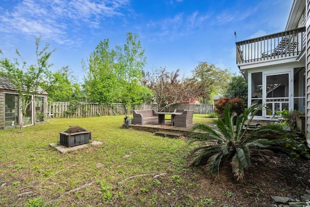 view of yard with a fenced backyard, a wooden deck, and a balcony