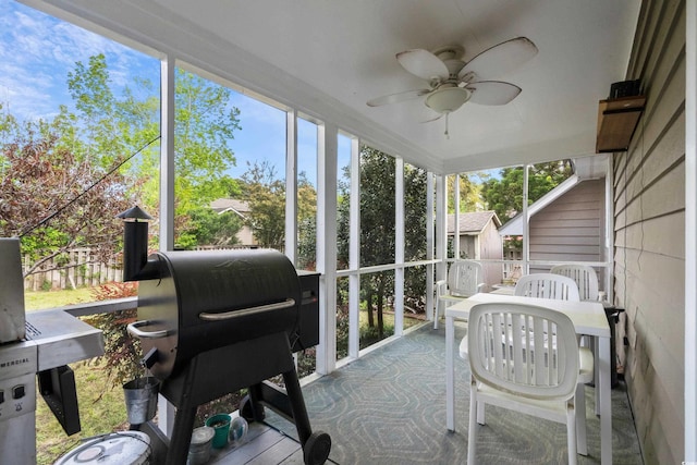 sunroom / solarium featuring a healthy amount of sunlight and ceiling fan