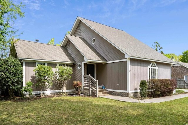 view of front of property with a front yard and a shingled roof