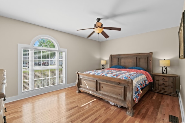 bedroom with baseboards, visible vents, and hardwood / wood-style flooring