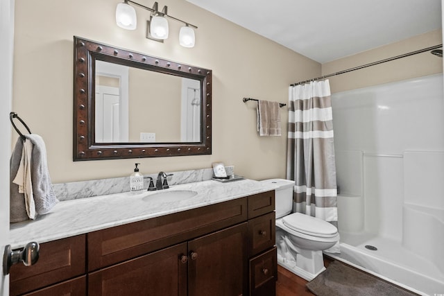 bathroom featuring toilet, curtained shower, vanity, and wood finished floors