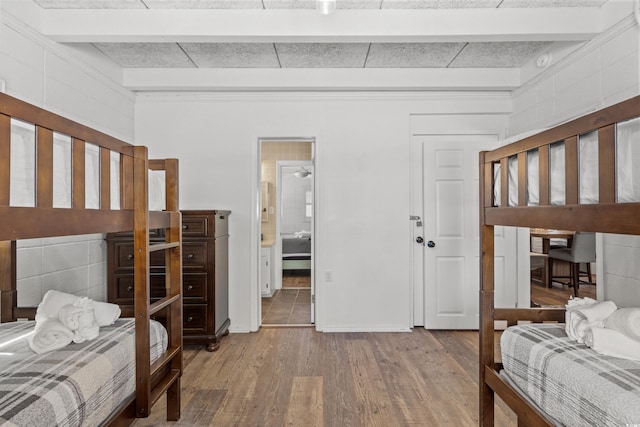bedroom featuring baseboards, crown molding, and wood finished floors