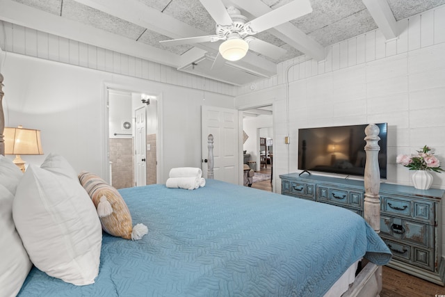 bedroom featuring ensuite bathroom, ceiling fan, beamed ceiling, attic access, and wood finished floors