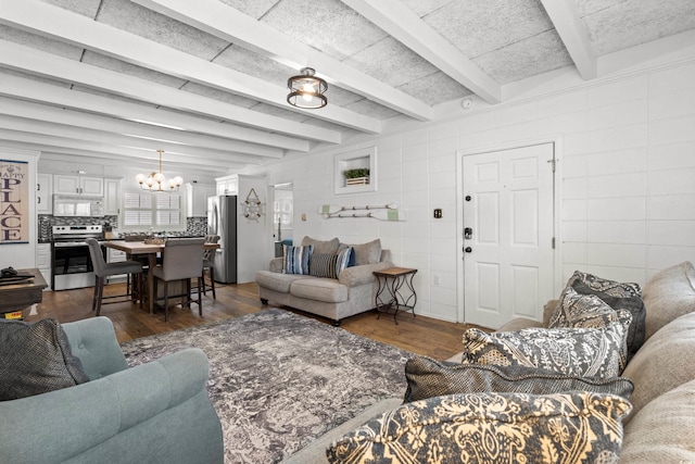 living room featuring a notable chandelier, tile walls, beam ceiling, and dark wood-style floors