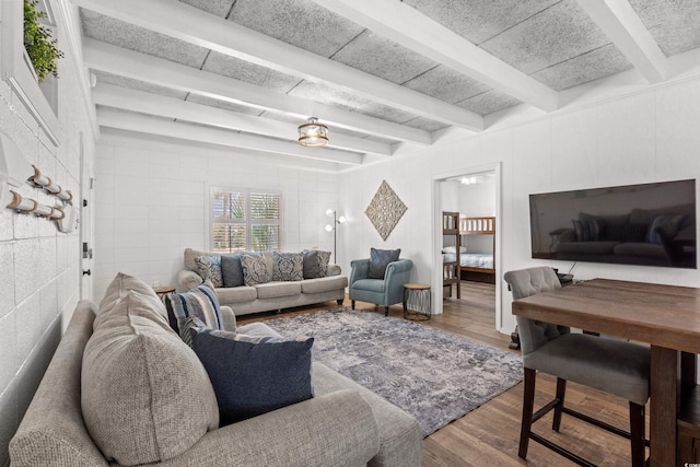 living room featuring beamed ceiling and wood finished floors
