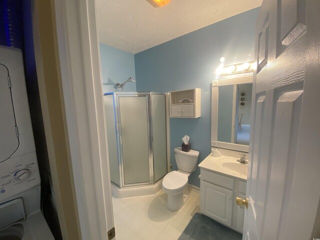 901-9 W Port Dr Unit 907, North Myrtle Beach, SC 29582 - full bath with stacked washer / drying machine, a stall shower, toilet, vanity, and a textured ceiling