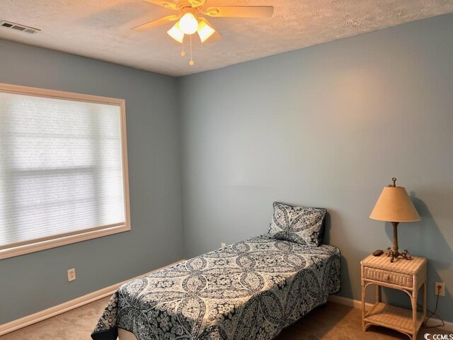 901-9 W Port Dr Unit 907, North Myrtle Beach, SC 29582 - carpeted bedroom featuring baseboards, ceiling fan, and a textured ceiling