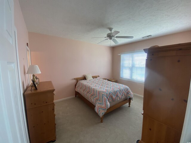 901-9 W Port Dr Unit 907, North Myrtle Beach, SC 29582 - bedroom with baseboards, light colored carpet, ceiling fan, and a textured ceiling