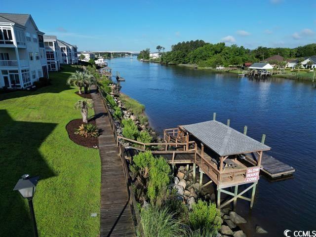 901-9 W Port Dr Unit 907, North Myrtle Beach, SC 29582 - dock featuring a water view and a lawn