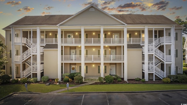 view of building exterior with stairway and uncovered parking