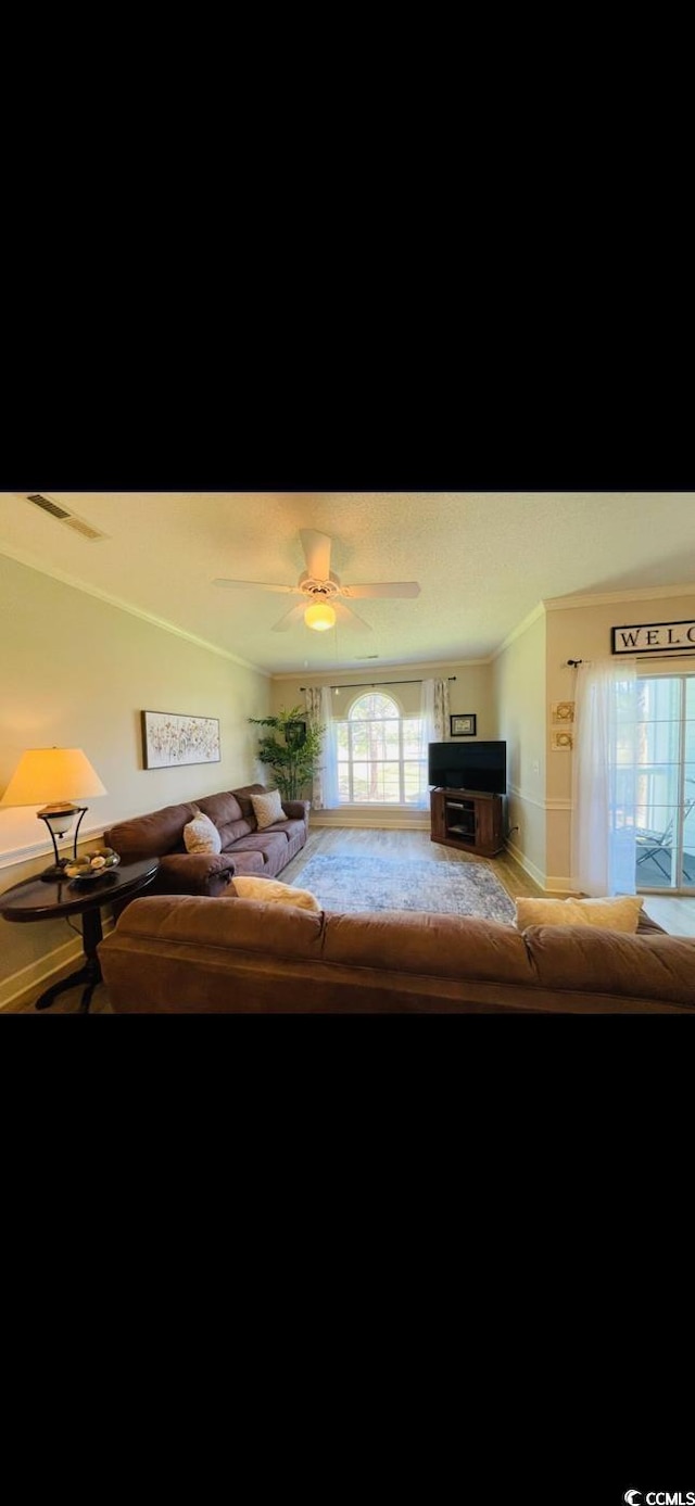 4669 Wild Iris Dr Unit 22-2O2, Myrtle Beach, SC 29577 - living room with visible vents, ceiling fan, and crown molding