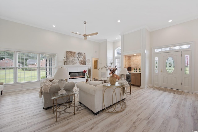 4100 Hagwood Cir, Conway, SC 29526 - living area featuring a towering ceiling, light wood-style floors, a glass covered fireplace, crown molding, and baseboards