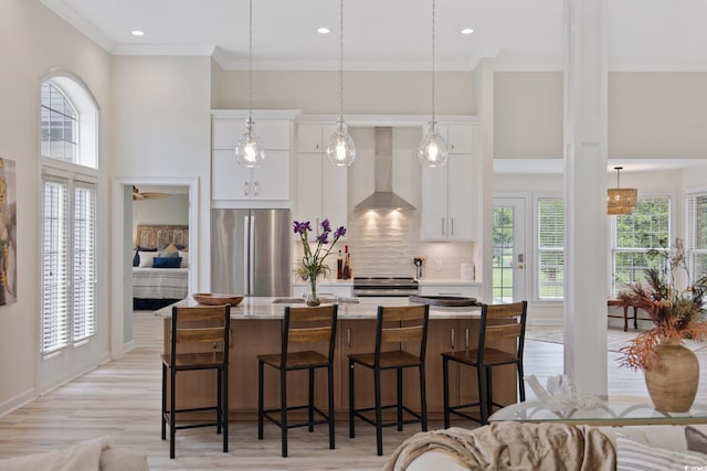 4100 Hagwood Cir, Conway, SC 29526 - kitchen featuring stainless steel appliances, wall chimney range hood, a kitchen island with sink, white cabinets, and ornamental molding