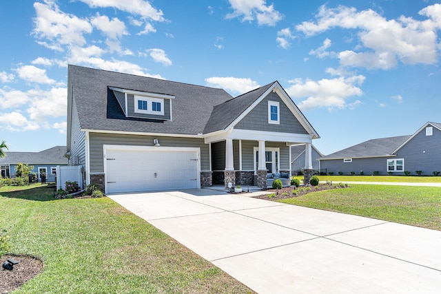 craftsman inspired home with a porch, concrete driveway, stone siding, and a front yard