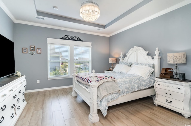 bedroom with baseboards, a raised ceiling, a notable chandelier, and light wood-style floors