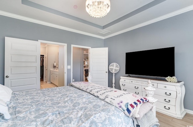 bedroom with baseboards, a raised ceiling, light wood-style floors, a chandelier, and ornamental molding